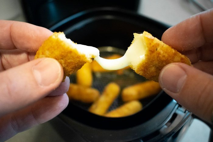 Air Fryer Frozen Mozzarella Sticks Recipe 13 pulling apart a cooked mozzarella stick