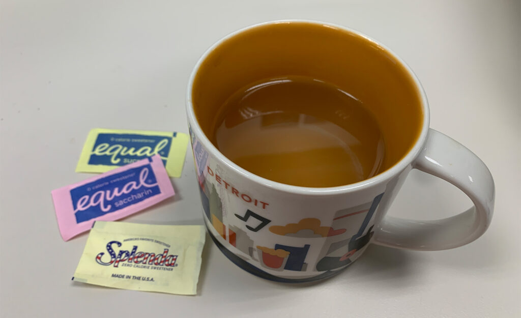 Can You Have Coffee With Stevia While Fasting? 5 Equal And Splenda Packets Next To Coffee Mug