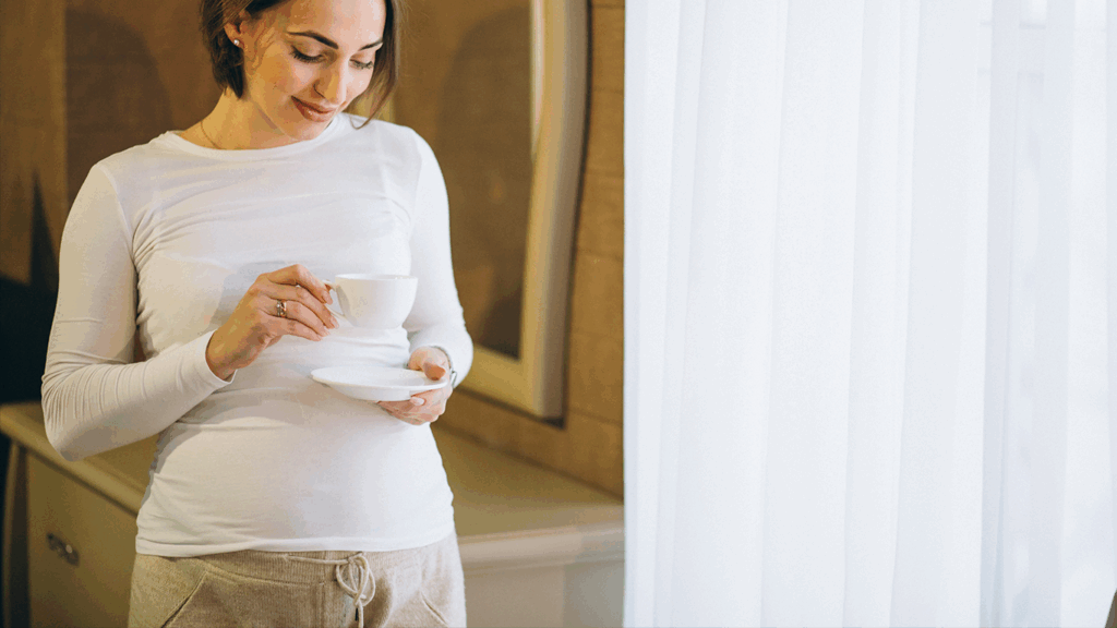 Pregnant Woman Holding A Coffee Cup.