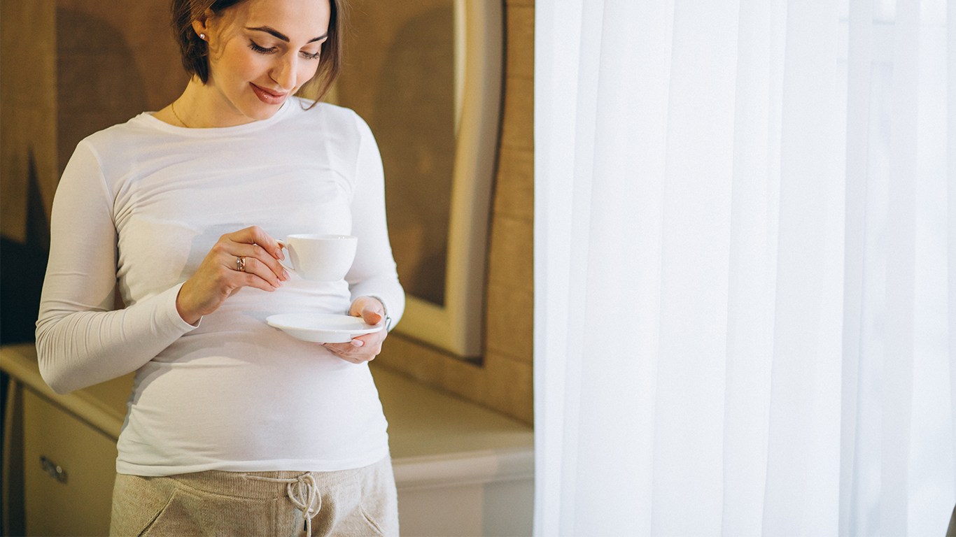 Pregnant Woman Holding A Coffee Cup.