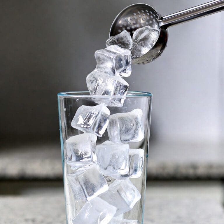 Ice cubes falling into glass