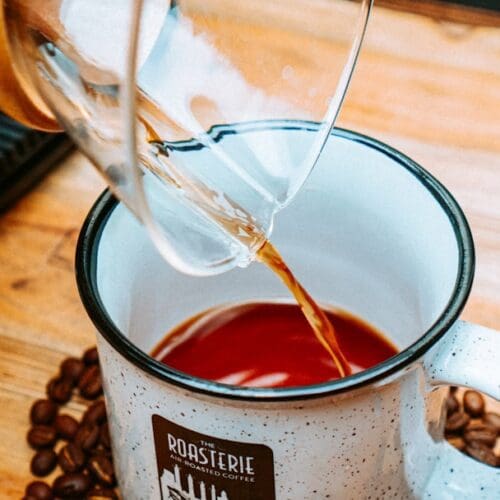 a person pours coffee into a mug